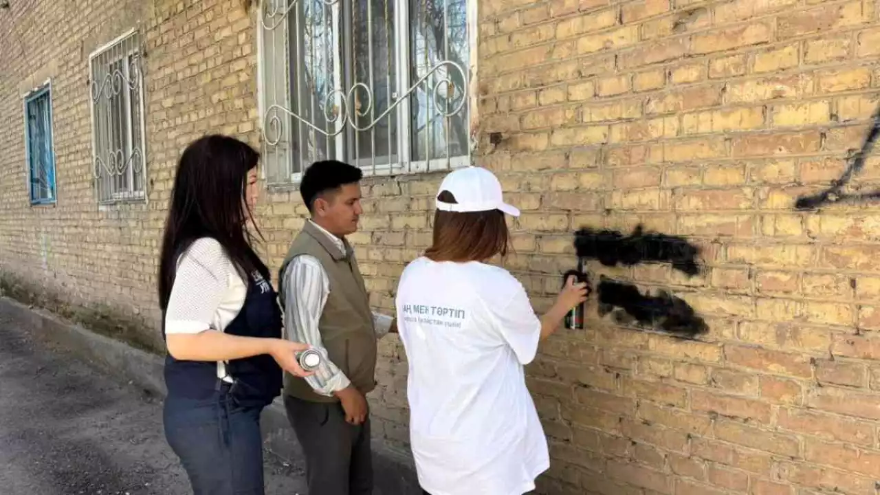 Жамбылдық жастар ғимарат қасбетіндегі граффити жазуларын өшірді